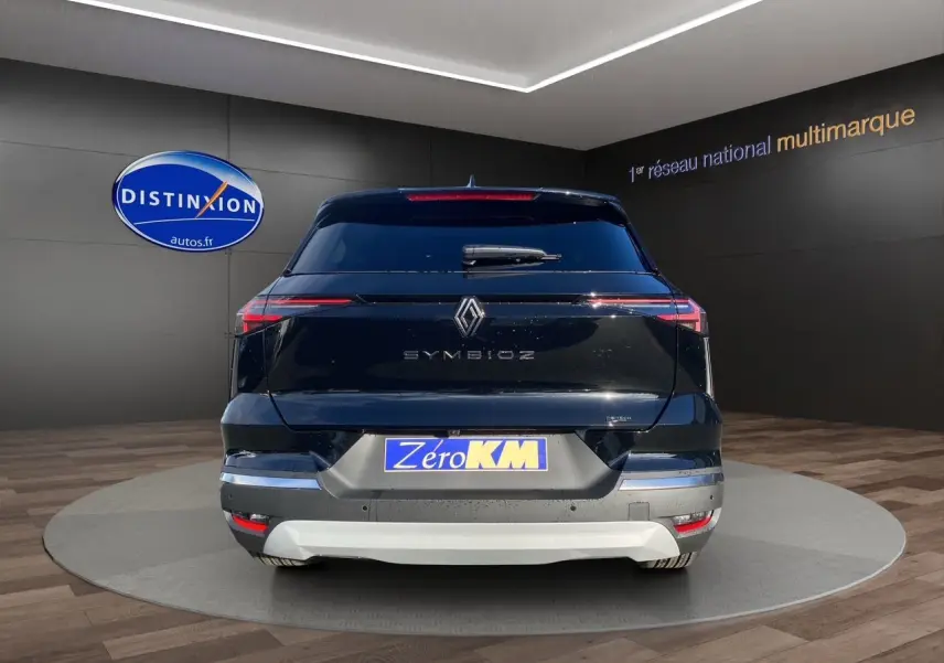 Vue arrière d'une Renault Symbioz noire étoile avec feux LED fins et plaque Zéro KM dans un showroom.