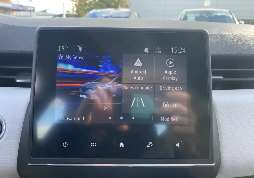 Écran tactile central de la Renault Clio blanche 2021 affichant les aides à la conduite et options multimédia.