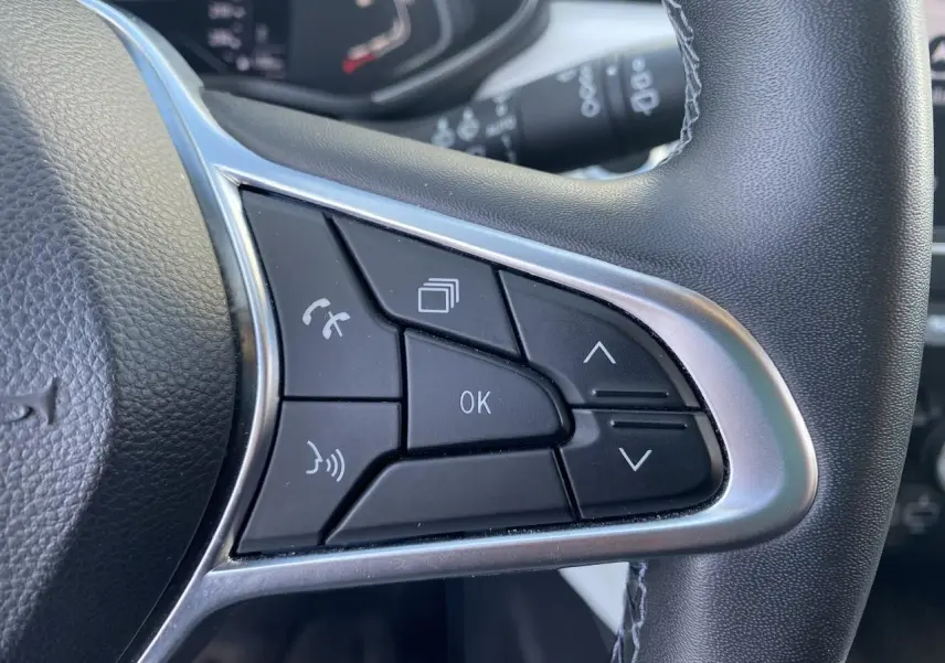 Gros plan sur les commandes multifonctions du volant côté gauche d'une Renault Clio blanche, version Intens 2021.