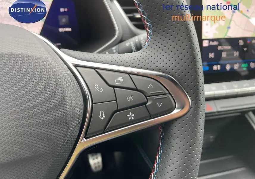 Gros plan sur le volant perforé avec surpiqûres tricolores du Renault Symbioz 2026, boutons de commande visibles.