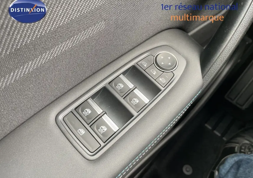 Gros plan sur la commande des vitres électriques côté conducteur d’une Renault Symbioz gris cassiopée métal.