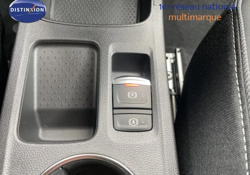 Gros plan sur la console centrale noire avec commandes de frein à main et fonction auto hold d'une Renault Symbioz gris cassiopée.