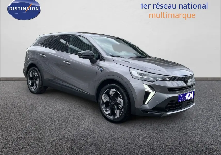 Renault Symbioz gris cassiopée métal en 3/4 avant droit, avec jantes stylisées et feux LED distinctifs.