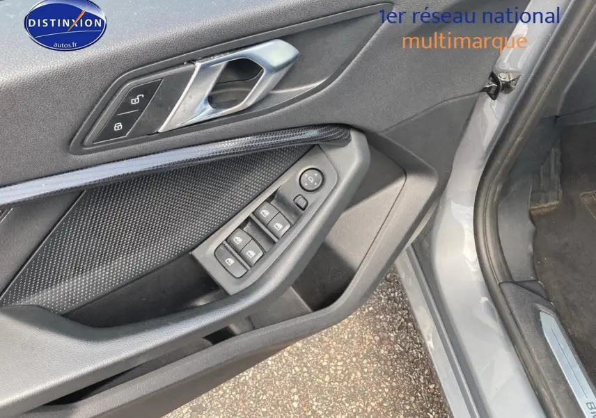 Vue rapprochée de la porte avant gauche grise de la BMW Série 1 F40 avec commandes de vitres et verrouillage.