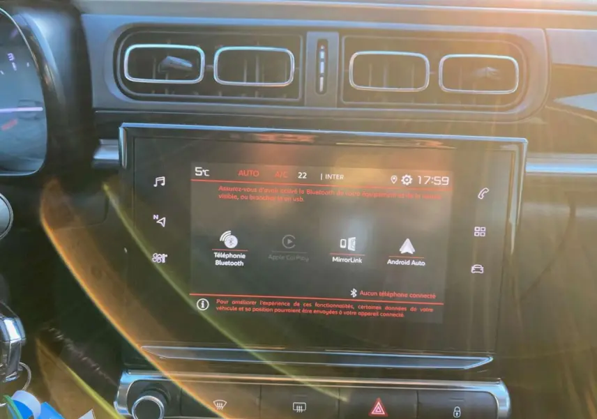 Écran tactile central de la Citroën C3 Shine 2023 avec commandes MirrorLink et Bluetooth, vue intérieure frontale.