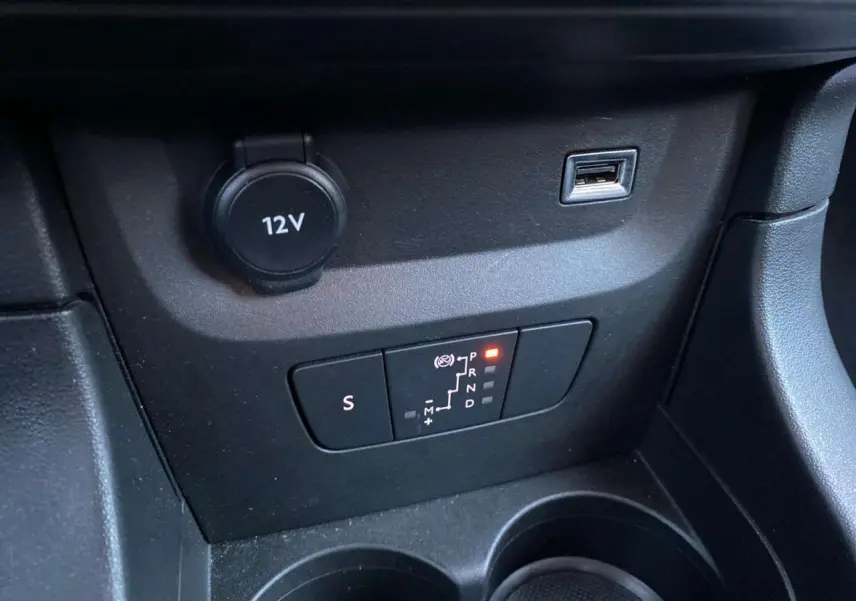 Gros plan sur la console centrale de la Citroën C3 Shine 2023, montrant la boîte auto et prise 12V noire.