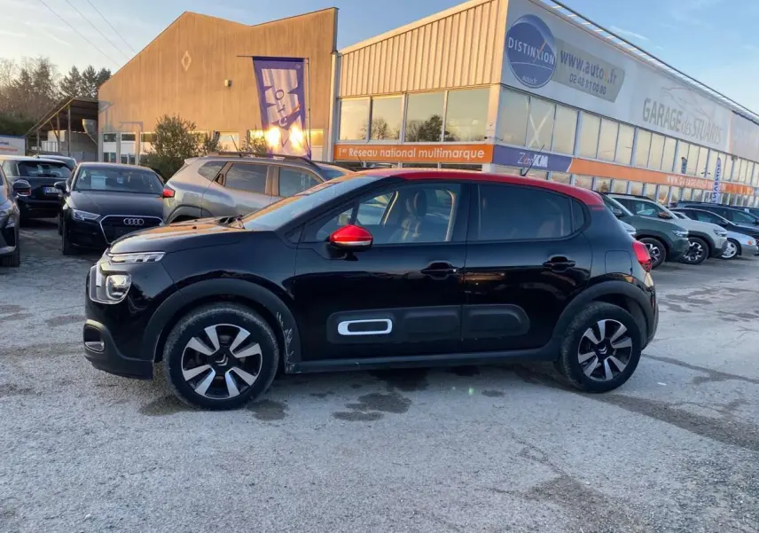 Citroën C3 Shine 2023 noir avec toit et rétroviseur rouge, vue profil côté gauche sur parking extérieur.