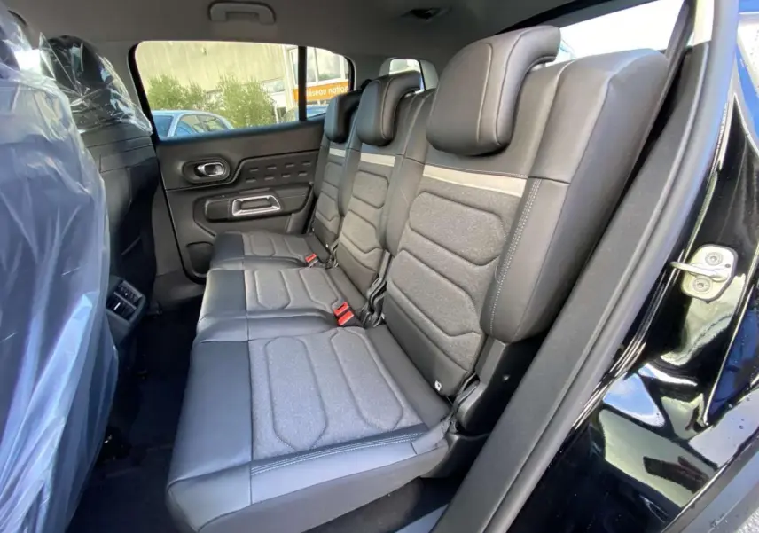 Vue côté droit des sièges arrière en cuir et tissu gris du Citroën C5 Aircross noir perla avec porte ouverte.