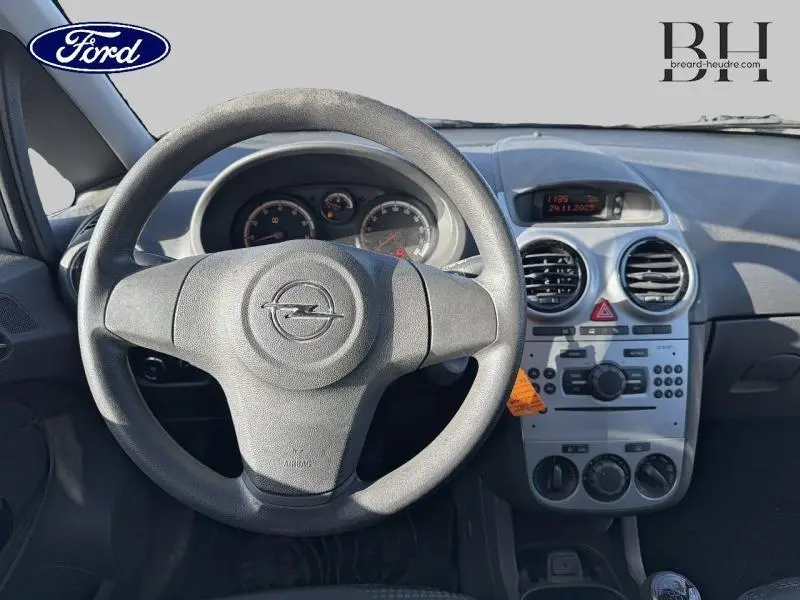 Vue intérieure centrée sur le volant Opel et le tableau de bord gris avec commandes et affichage digital.