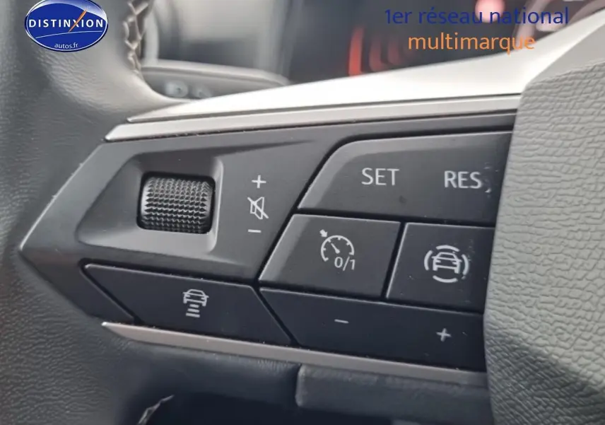 Gros plan sur les commandes du volant cuir noir de la SEAT Arona 2025, avec boutons de régulateur de vitesse et aides à la conduite.