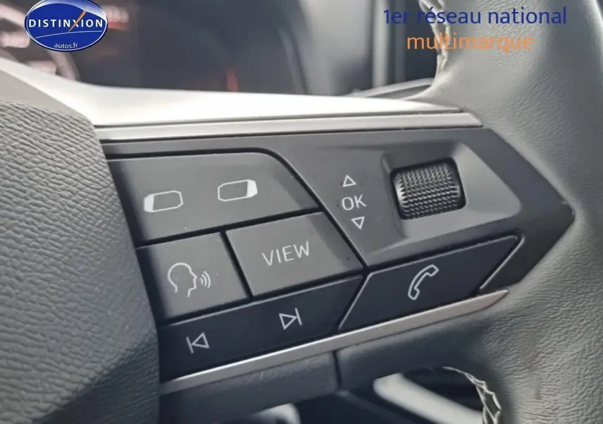 Gros plan sur les commandes multifonctions du volant cuir noir du SEAT Arona gris magnétique 2025.