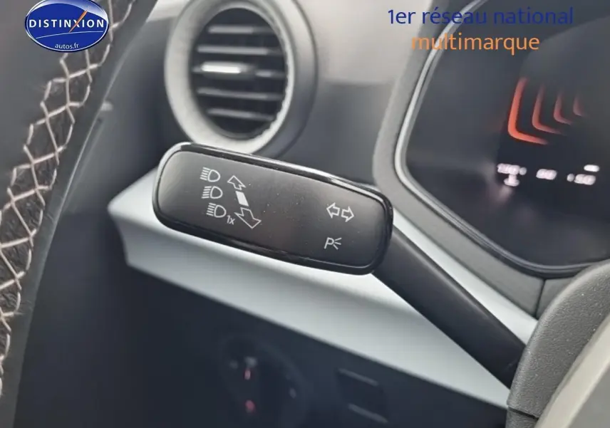 Gros plan sur la commande de clignotants et feux au volant d'un SEAT Arona gris magnétique 2025.