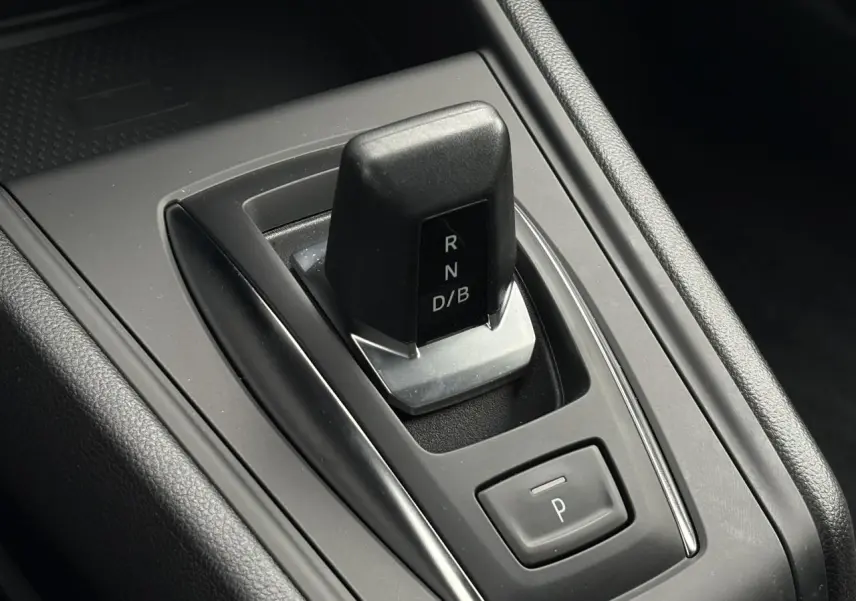 Gros plan sur la commande de boîte automatique noire du Renault Captur 2025, avec bouton de parking intégré.