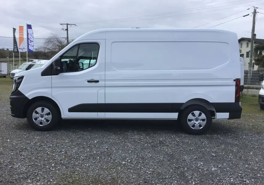 Vue de profil côté gauche d’un Renault Master blanc L2H2 avec protections noires sur les bas de caisse et jantes argentées.