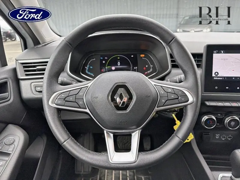 Vue intérieure centrée sur le volant noir de la Renault Clio hybride 2021 avec tableau de bord numérique et écran tactile.