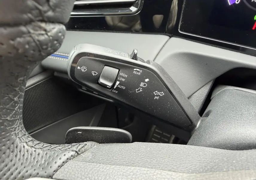 Gros plan sur la commande des essuie-glaces à gauche du volant cuir du Volkswagen Tiguan gris 2025.