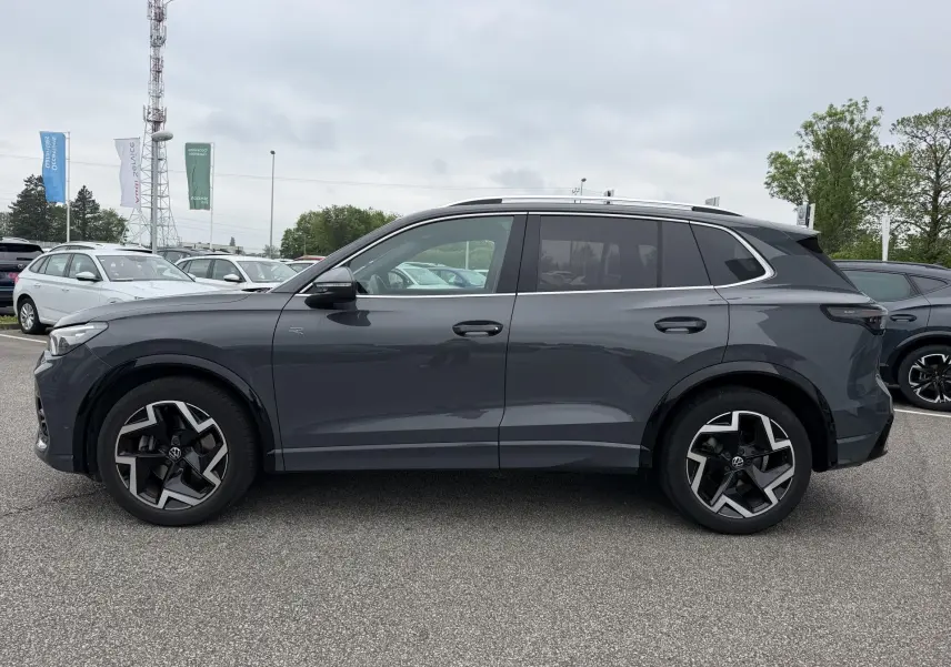 Vue de profil côté gauche d’un Volkswagen Tiguan gris métallisé 2025 avec jantes alliage 19 pouces et vitres teintées.