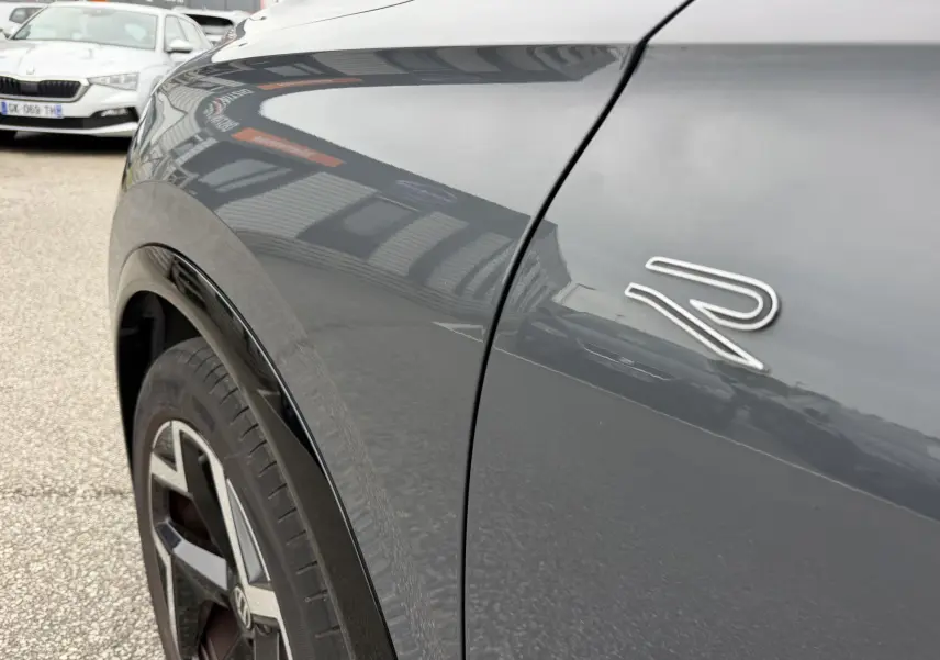 Gros plan sur l'aile avant gauche grise du Volkswagen Tiguan 2.0 TDI avec logo R et jante alliage 19 pouces.