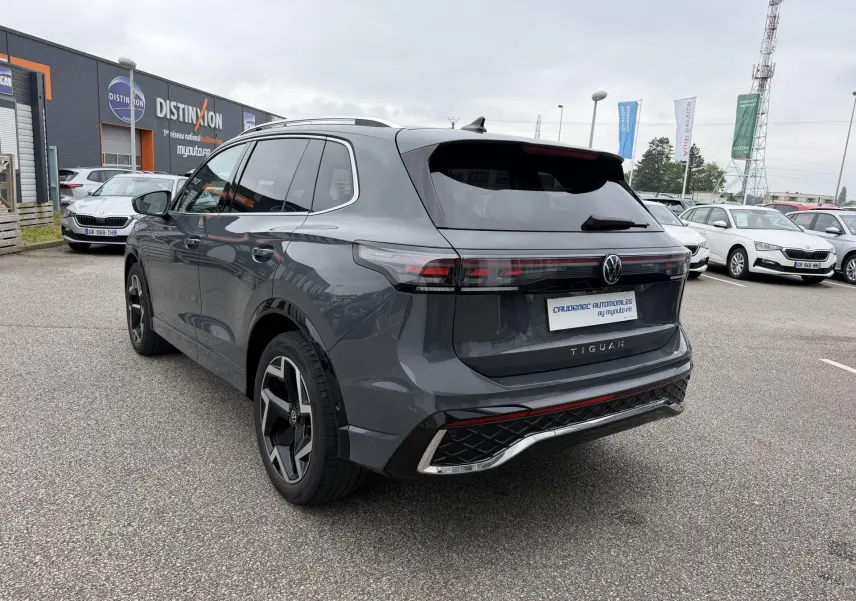 Vue 3/4 arrière droite d'un Volkswagen Tiguan gris métallisé avec jantes alliage 19 pouces et pack R-Line extérieur.