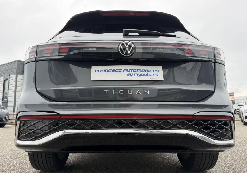 Vue arrière du Volkswagen Tiguan gris métallisé 2025, avec feux arrière LED et logo central visible.