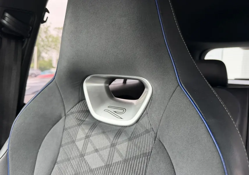 Gros plan sur le siège avant gris avec surpiqûres bleues et logo R du Volkswagen Tiguan 2025.