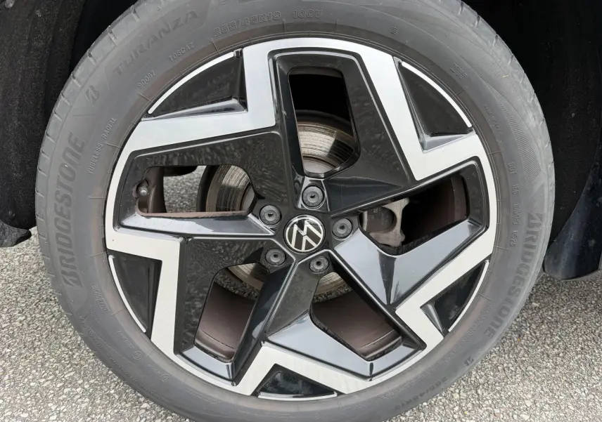 Gros plan sur la jante alliage 19 pouces bicolore noire et argentée du Volkswagen Tiguan 2025 gris.