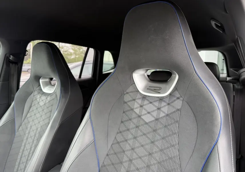 Gros plan sur les sièges avant sport gris avec surpiqûres bleues du Volkswagen Tiguan 2025 version R-Line.