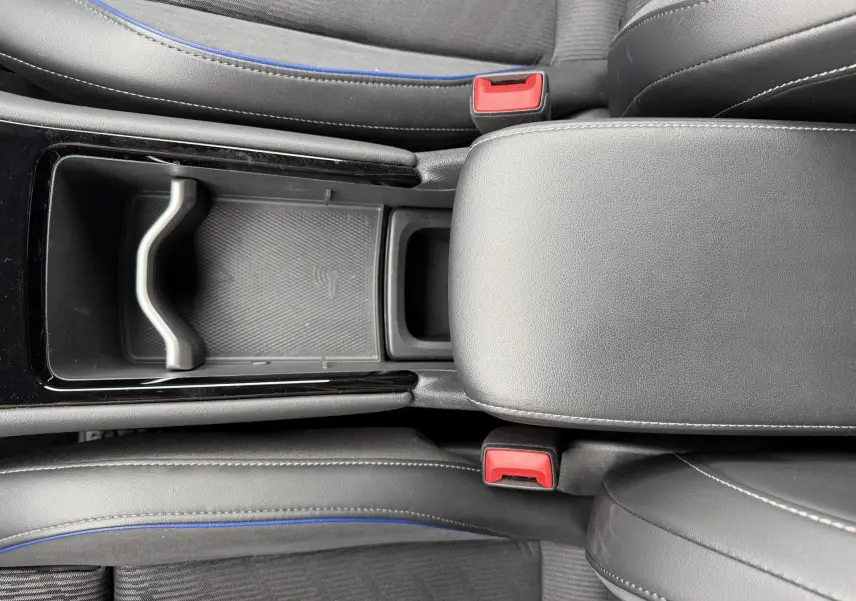 Vue plongeante sur la console centrale en cuir noir avec surpiqûres blanches et sièges gris à surpiqûres bleues du Volkswagen Tiguan 2025.