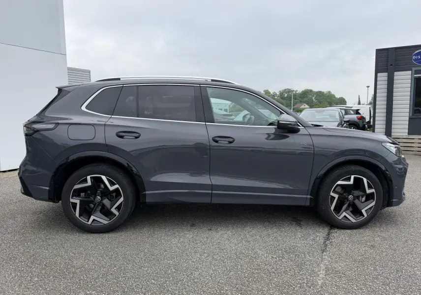 Vue de profil côté gauche d’un Volkswagen Tiguan gris métallisé 2025 avec jantes alliage 19 pouces et pack R-Line extérieur.