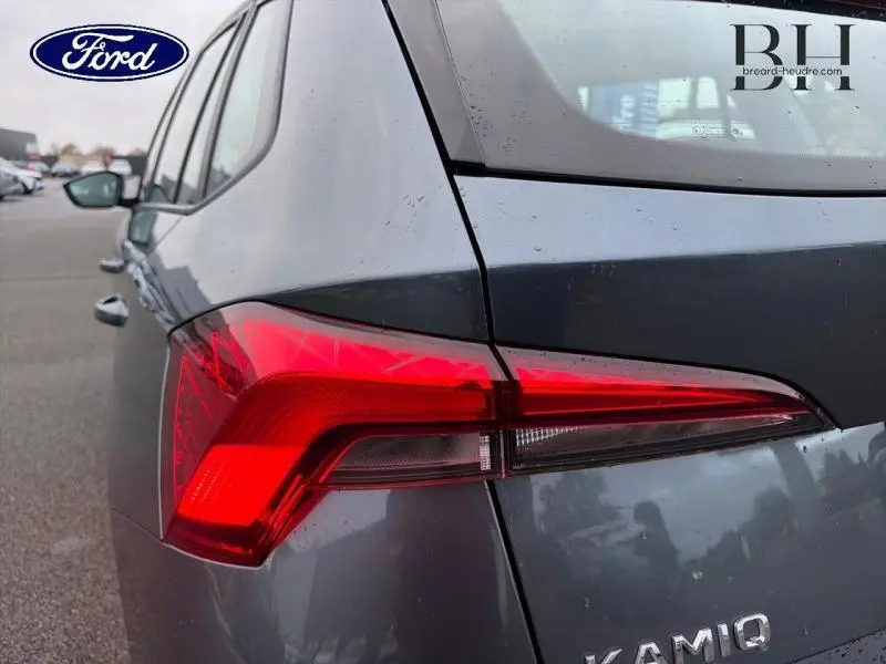 Gros plan sur le feu arrière gauche rouge vif d'un Skoda Kamiq gris Météore 2021, soulignant sa ligne arrière.