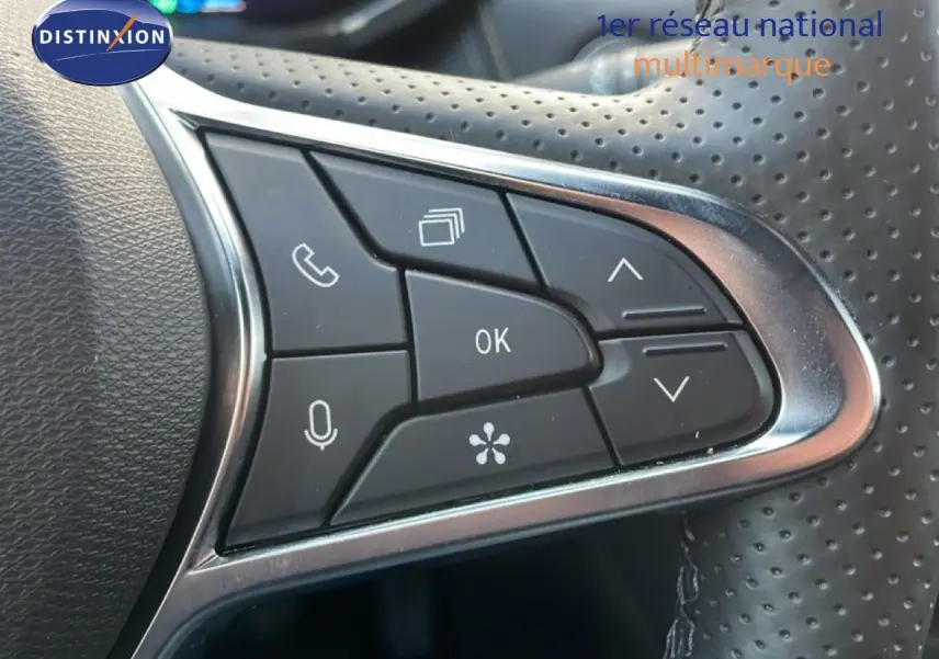 Gros plan sur les commandes multifonctions du volant perforé d’une Renault Symbioz gris cassiopée métal, version hybride 2025.