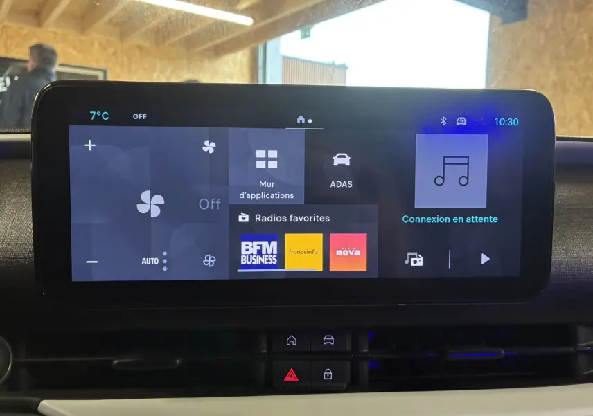 Écran tactile central de la Fiat 600 1.2 Hybrid 2024 affichant les radios favorites et les réglages climatiques.