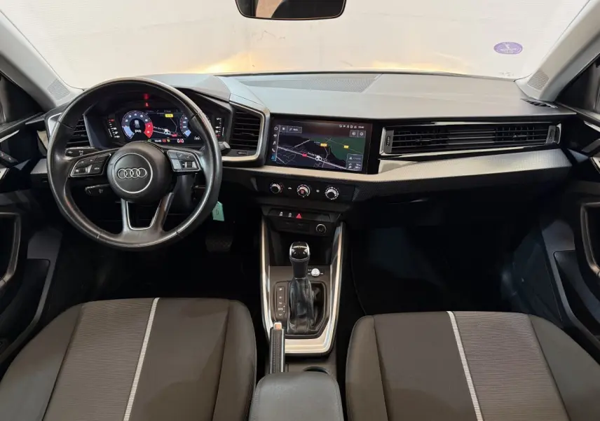 Vue intérieure avant de l'Audi A1 2021 avec volant cuir multifonctions et écran tactile de navigation.