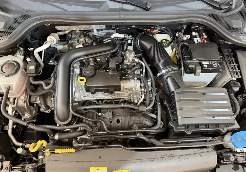 Vue plongeante sur le moteur essence noir et gris de l'Audi A1 1.0 TFSI 110 S tronic 7 Business Line de 2021.