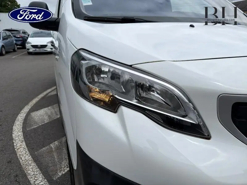 Gros plan sur le phare avant droit du Peugeot Expert Fourgon blanc Banquise, mettant en valeur son design moderne.