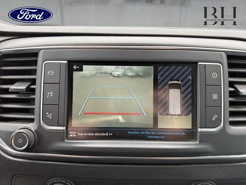 Écran tactile du système multimédia montrant la caméra de recul et l’aide au stationnement du Peugeot Expert Fourgon blanc.