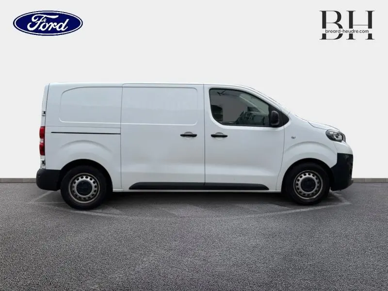 Vue de profil côté gauche d'un Peugeot Expert Fourgon blanc Banquise, fourgon utilitaire avec portes latérales et roues acier.