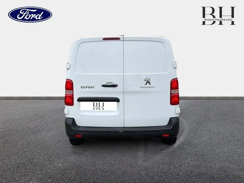 Vue arrière d’un Peugeot Expert Fourgon blanc Banquise avec portes battantes et logo visible sur fond neutre.