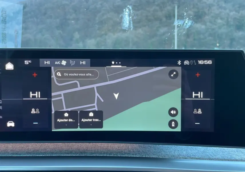 Écran tactile incurvé du tableau de bord du Peugeot 5008 gris titane, affichant la navigation GPS et la climatisation.