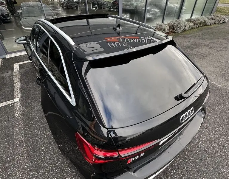Vue arrière en plongée d'un Audi RS6 Avant noir 2021 avec feux LED et toit ouvrant panoramique visible.
