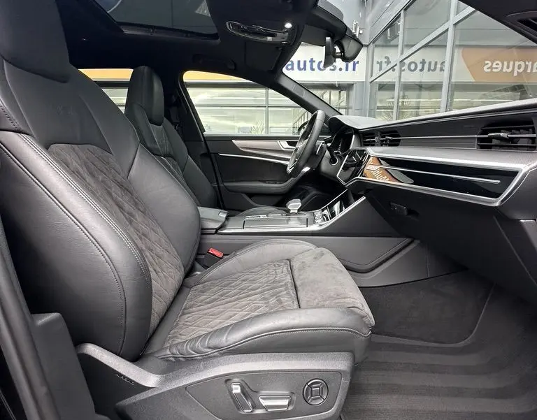 Vue intérieure côté conducteur de l'Audi RS6 Avant 2021 noire, avec sièges sport en cuir et alcantara, toit ouvrant panoramique.