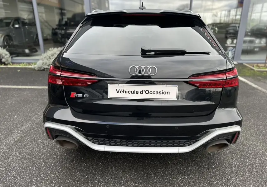 Vue arrière d'une Audi RS6 Avant noire de 2021 avec double sortie d'échappement et logo RS6 visible.