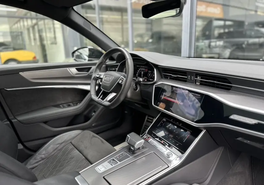 Intérieur noir de l'Audi RS6 Avant 2021 vu côté conducteur, avec tableau de bord digital et console tactile moderne.