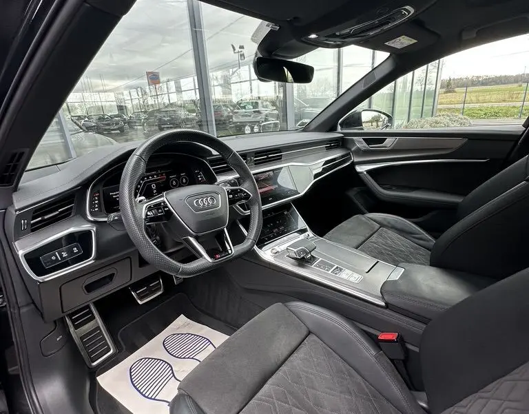 Intérieur noir de l'Audi RS6 Avant 2021 vu côté conducteur, avec volant sport et toit ouvrant panoramique.