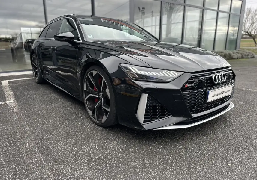 Audi RS6 Avant noire vue en 3/4 avant gauche, avec calandre noire et jantes sport à cinq branches doubles.
