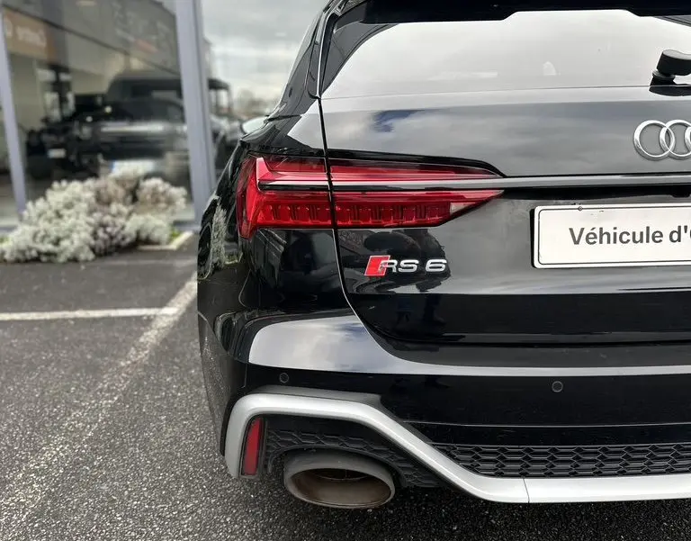 Vue arrière gauche d'une Audi RS6 Avant noire 2021 avec feux LED et double sortie d'échappement distinctive.