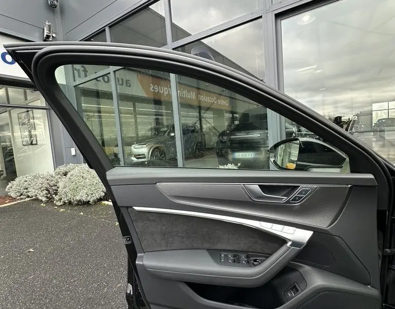 Porte côté conducteur ouverte d'une Audi RS6 Avant noire 2021, montrant l'intérieur avec garnitures noires et inserts argentés.