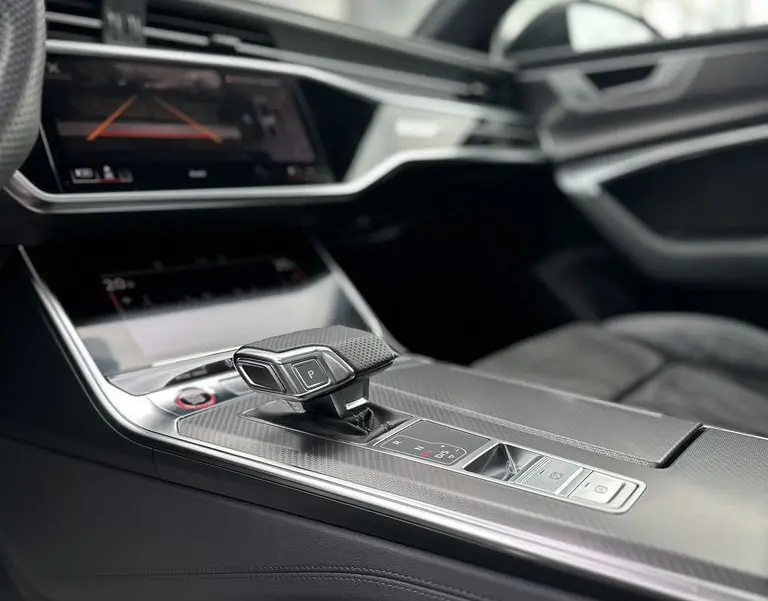 Intérieur noir de l'Audi RS6 Avant 2021, vue sur la console centrale avec levier de vitesses automatique moderne.