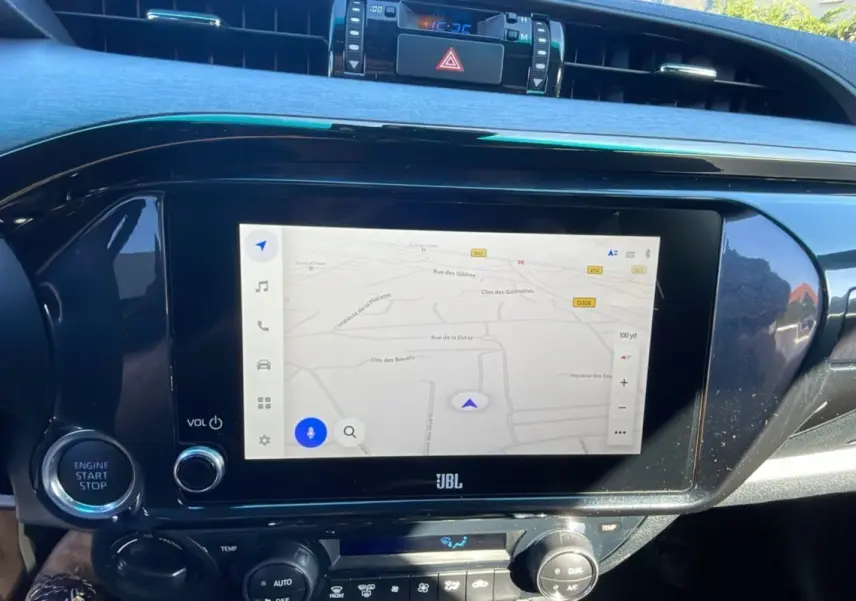 Écran tactile central avec navigation GPS et commandes climatisation dans le tableau de bord du Toyota Hilux 2025 Noir Attitude.