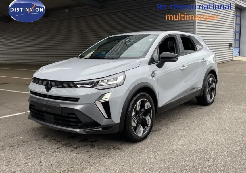 Renault Symbioz gris Rafale métal en 3/4 avant droit, SUV hybride avec jantes bicolores et calandre noire distinctive.